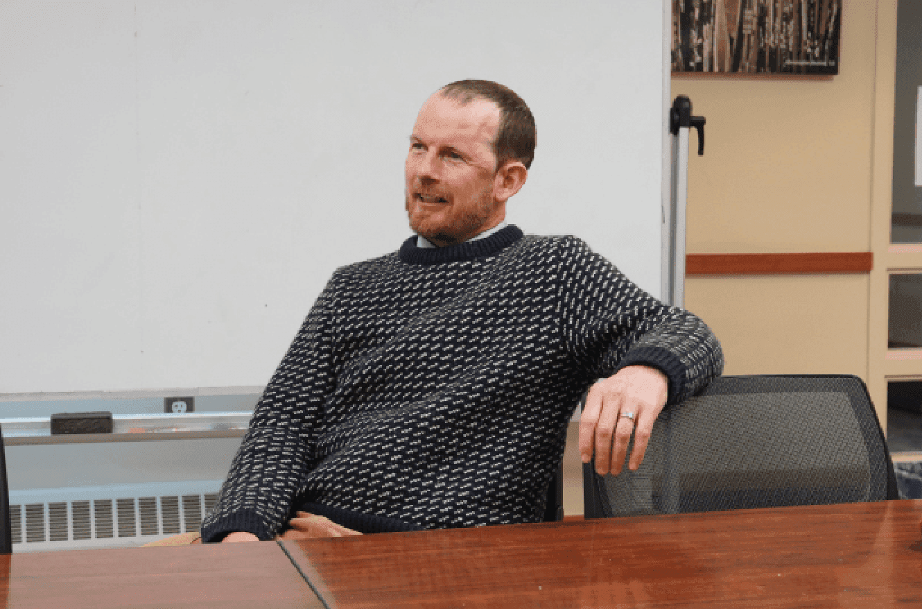 “I was walking down the street and…” 
You would probably expect a story, but if Mr. Whittemore is your math teacher, you know that he likes to frame his classes in the form of a narrative. If you hear his iconic sentence, you know he is moving on to the next homework problem. Surrounded by chattering students in EPAC 319, Instructor in Mathematics Tim Whittemore is seated at the head of the table. 